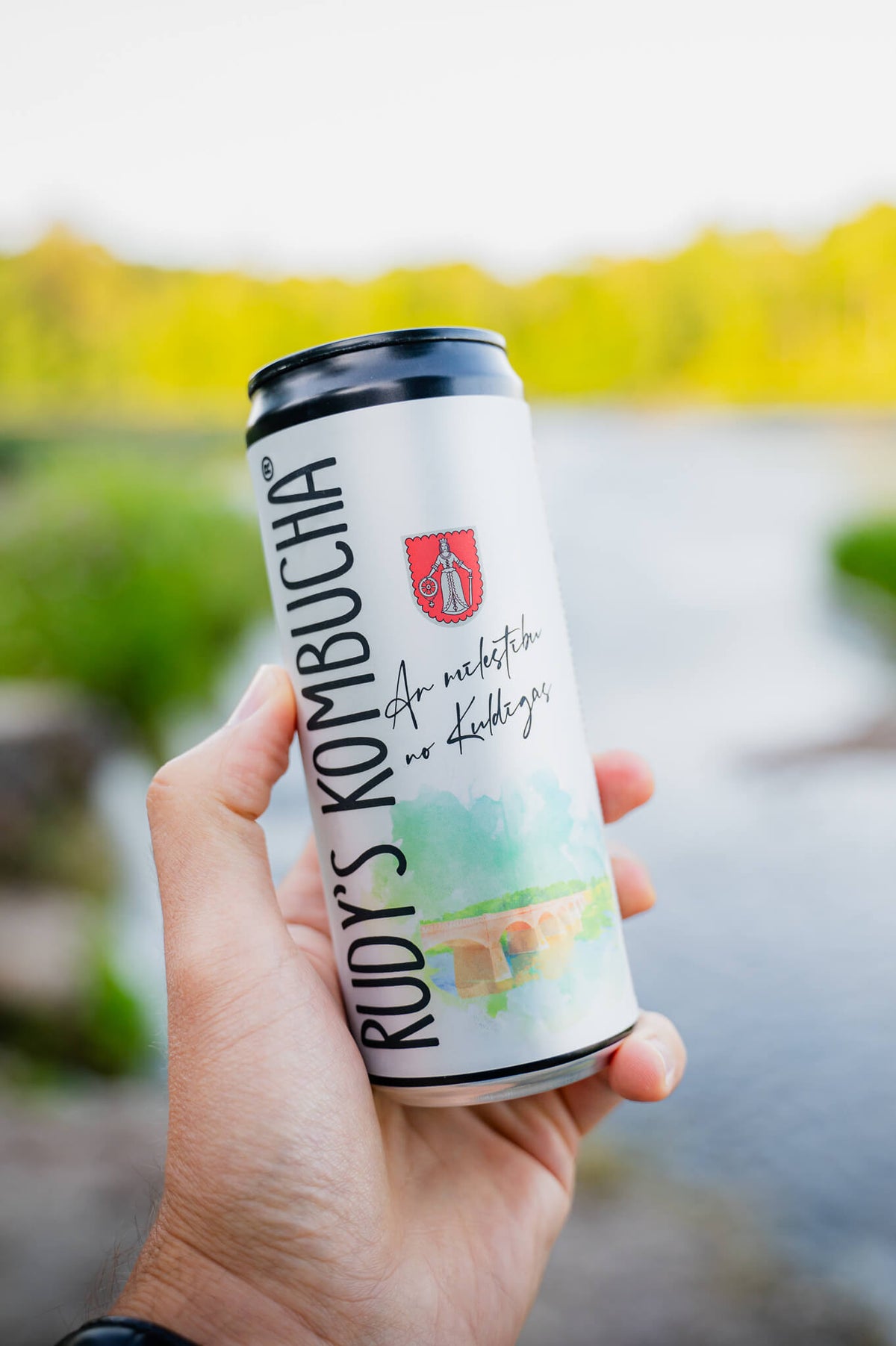 En hand som håller burken With Love from Kuldiga vid floden