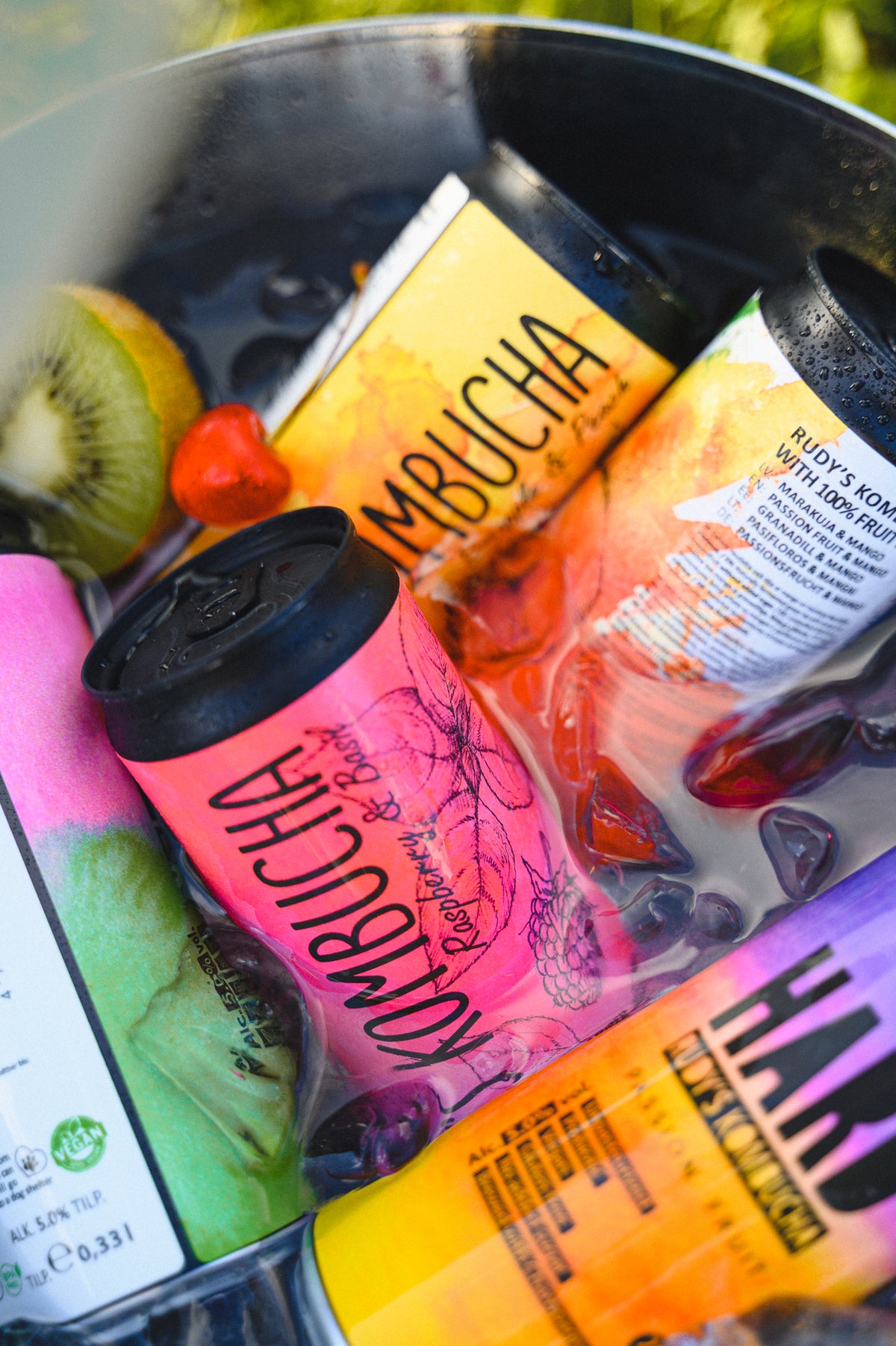 Burkar med Rudy's Kombucha i en ishink med färsk frukt